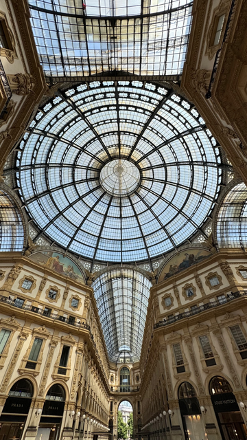 Ornate, large ceiling windows, one circular and several arch-shaped architecturally beautiful designs.