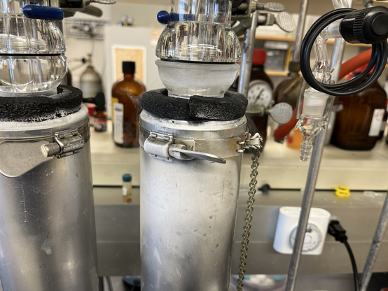 Nitrogen boiling out of a Dewar flask as solvent condenses in the trap of a vacuum manifold. The cold boiling gas flows downward and condenses water vapor, which is visible