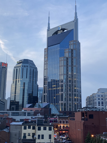 Photo of the Regions and AT&T buildings in Nashville, the latter is commonly known as ‘the Batman building’.  A lit-up and lively Honky Tonk is at the bottom of the photo.