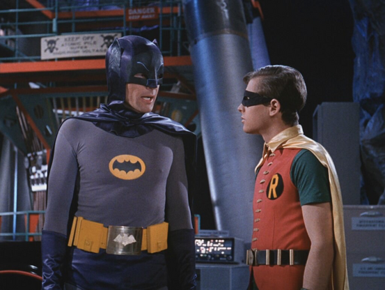 Photo of Batman (Adam West) and Robin (Burt Ward) in the Bat Cave trying to solve the riddle.